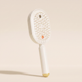 The Ivresse Mist and Glow Brush in beige, showing the cream bristles and champagne gold handle tip.