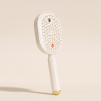 The Ivresse Mist and Glow Brush in beige, showing the cream bristles and champagne gold handle tip.